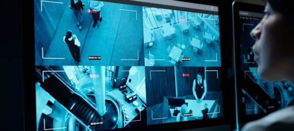 Screen of desktop computer with cctv video from every floor of modern hotel with staff working and clients or travelers with baggage.
