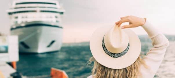 Woman tourist standing in front of big cruise liner, travel female.