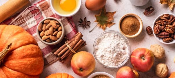 Autumn fall baking ingredients. Organic pumpkins, apples, pecan and almonds and seasonal spices, creative flat lay. Making pumpkin or apple pie for Thanksgiving and autumn holidays.