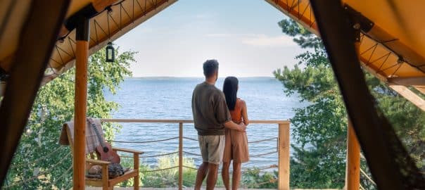 Rear view of affectionate couple enjoying summer vacation in glamping house.