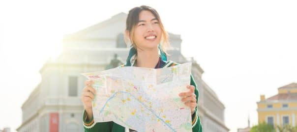 young tourist with a map discovers the city at sunset.