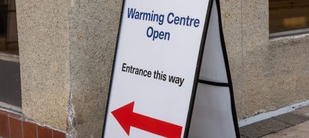 A sign directing people who are homeless or vulnerable to a warming center set up to provide shelter form the cold weather in winter.