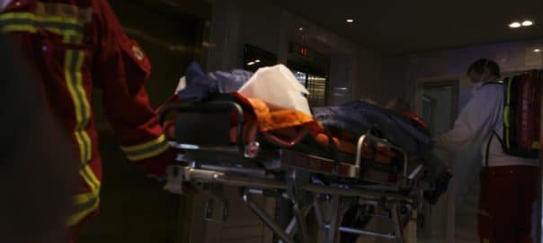Death at hotel. Paramedics wheel body away.