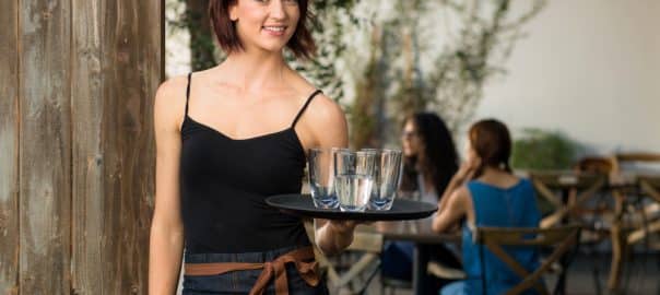 Young vibrant cheerful working waitress portrait modern trendy restaurant hip hair.