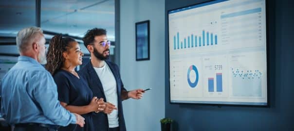 Company Operations Manager Holds Meeting Presentation. Diverse Team Uses TV Screen with Growth Analysis, Charts, Statistics and Data. People Work in Business Office.