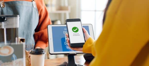 QR code payment, customer using smartphone for paying at shop.