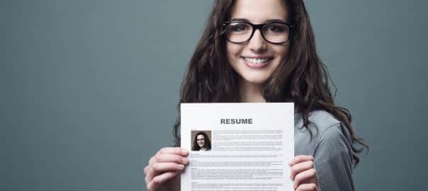 Young smiling cheerful woman holding her resume.