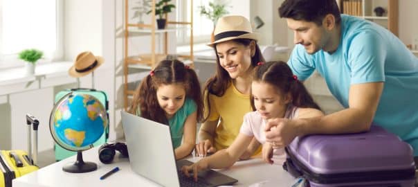 Happy people planning holiday trip. Family getting ready for travel vacation using laptop computer to monitor prices, pick airline, buy tickets, purchase flight, look for rentals or book hotel room.