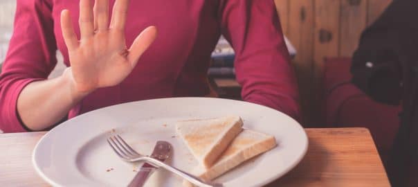 A woman on a gluten free diet is saying no thanks to toast.