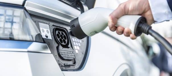 The driver of the electric car inserts the electrical connector to charge the batteries.