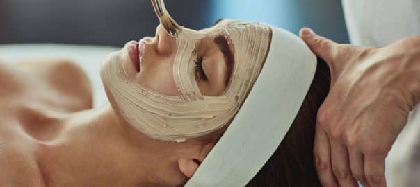 Woman, spa and face mask with brush or apply, pamper weekend and skincare wellness with client. Facialist, treatment and skin rejuvenation or pore tightening, relaxation and facial with people.