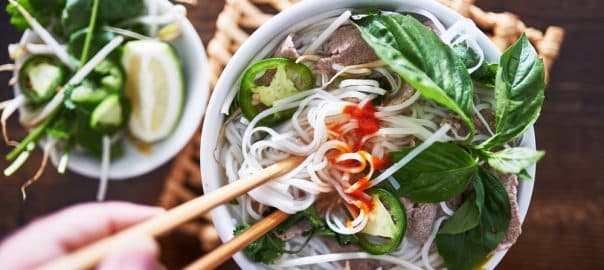 Vietnamese pho with spicy sriracha sauce shot top down.