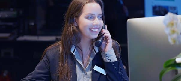 Hotel administrator. A woman-reception worker accepts an order for booking a room by phone. Profile shot of attractive executives at the reception of a hotel. The concept of service.