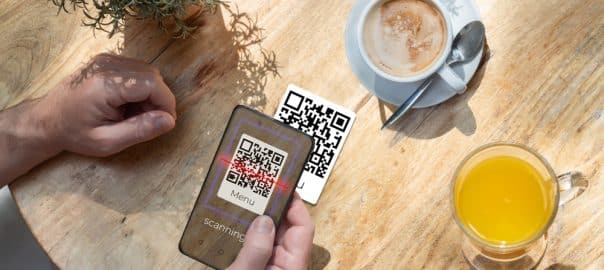 A customer scanning a qr code with his cell phone in a bar or restaurant to read the menu. The hospitality industry and new technologies.
