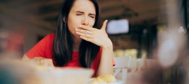 Woman Feeling Sick and Disgusted by Food Course in a Restaurant. Unhappy person having health problems after eating in a diner.