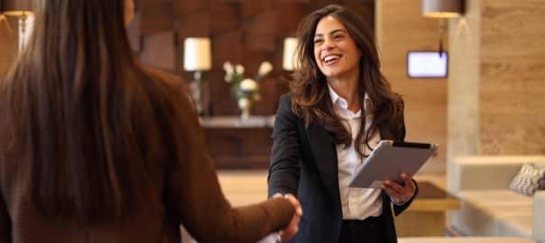 Two businesswomen gather in the office lobby to talk about their business plans.