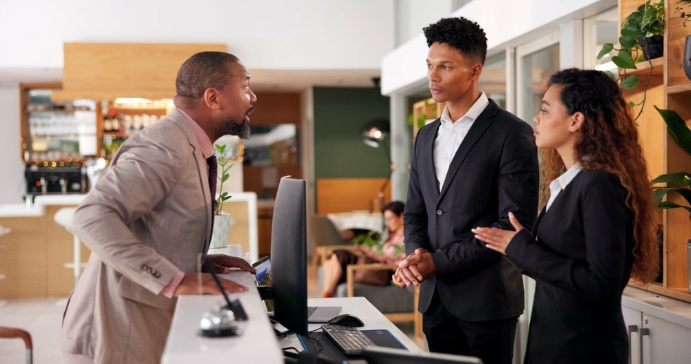 Anger, Receptionist,And,People,At,Front,Desk,Of,Hotel,For Anger, receptionist and people at front desk of hotel for frustrated client, lost luggage and check in problem. Customer service, concierge and late booking with man in lobby for appointment error